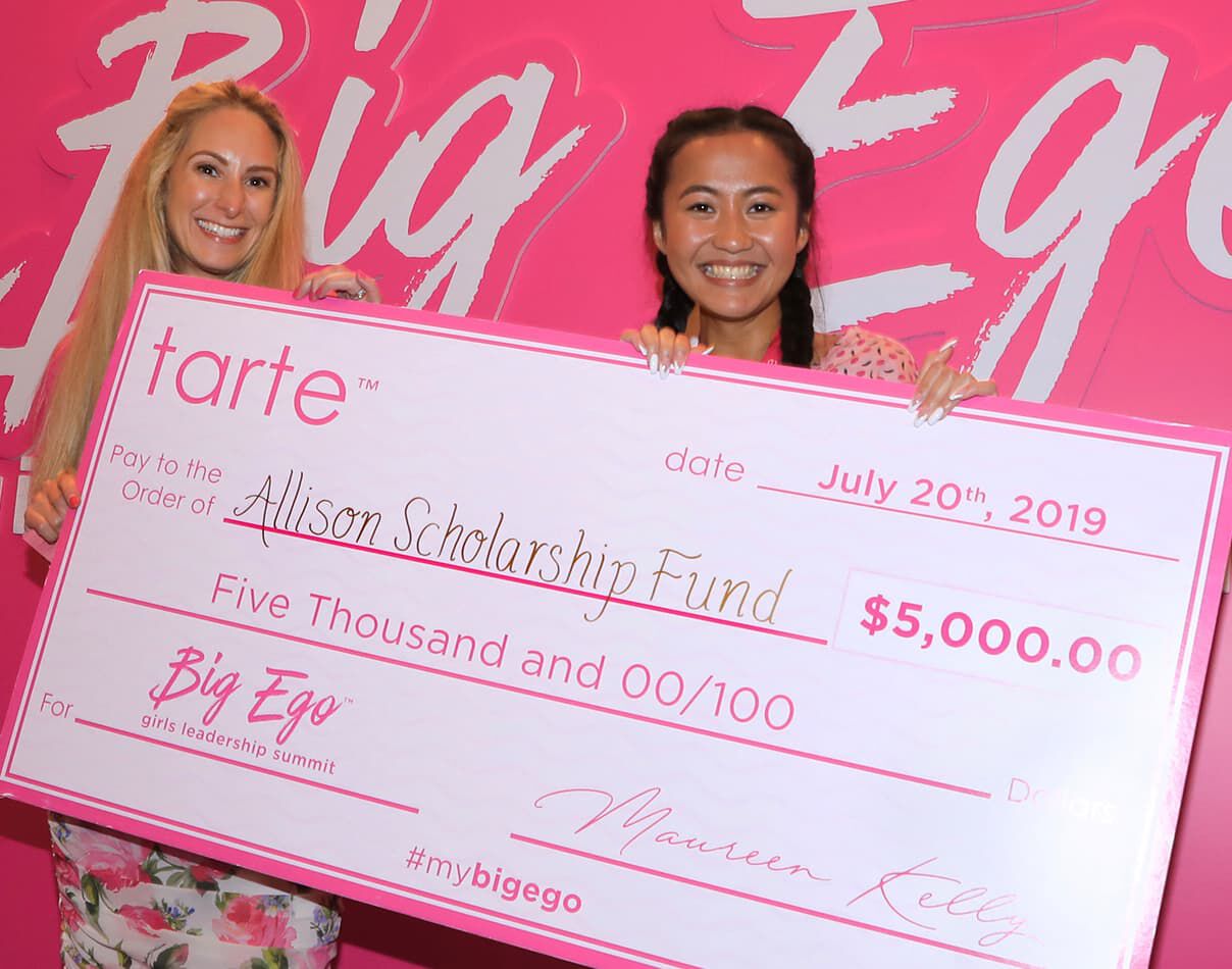 Tarte President, Candace with a big ego leadership conference winner holding a check